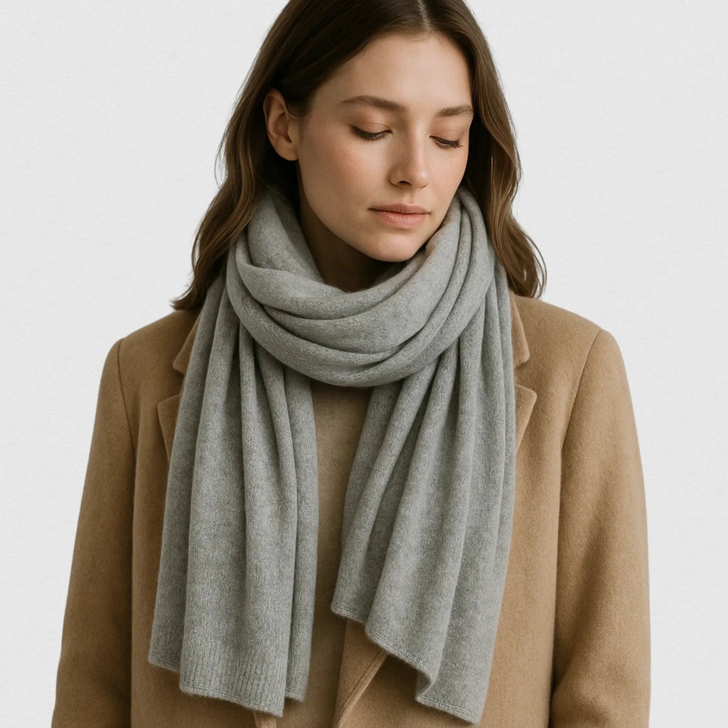 Femme portant une écharpe en cachemire gris clair 200×60 cm, manteau camel, style Maison Amavia chic et doux.