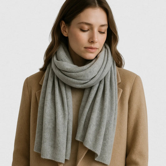 Femme portant une écharpe en cachemire gris clair 200×60 cm, manteau camel, style Maison Amavia chic et doux.