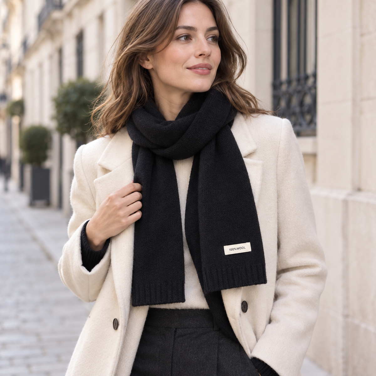 Écharpe noire en laine tricotée pour femme portée en tenue d’hiver