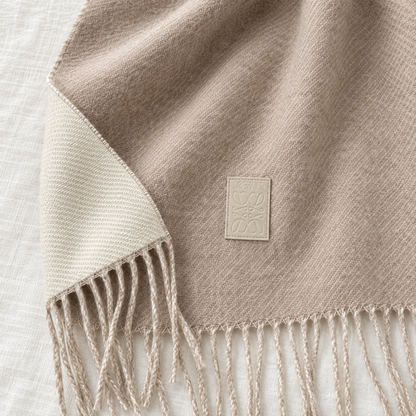 Détail de l’étiquette cousue et de la matière de l’écharpe beige