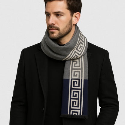 Homme portant une écharpe grise et bleu marine imitation cachemire avec motif grec sur fond gris perle – Maison Amavia