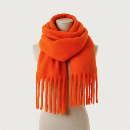 Écharpe orange mandarine oversize avec franges, présentée sur un mannequin beige Maison Amavia